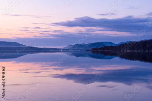 風景を湖面に反射する早朝の湖。北海道の屈斜路湖。 © Masa Tsuchiya