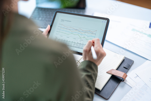 Young successful employee business woman 20s in casual shirt sit work at white office desk with pc laptop point index finger aside on workspace area on office background studio portrait