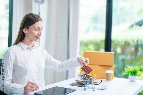 Concept of Online shopping, e-commerce, Woman holding credit card and using laptop computer for shopping online,Businesswoman paying for goods or services using credit card through online channels