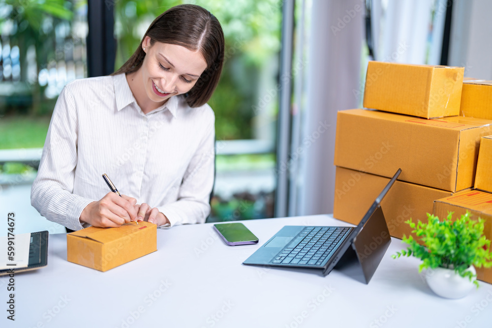 Startup, delivery and shipping in boxes for online shopping business. Businesswoman packing products from online business in a box to ship to clients and buyers.business woman working in the office Startup, delivery and shipping in boxes for online shopping business. Businesswoman packing products from online business in a box to ship to clients and buyers.business woman working in the office