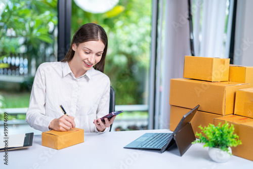 Startup, delivery and shipping in boxes for online shopping business. Businesswoman packing products from online business in a box to ship to clients and buyers.business woman working in the office © ND STOCK