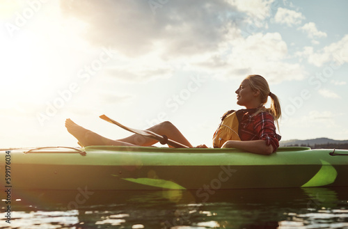 Enjoying the tranquility that comes with the trip. a young woman kayaking on a lake. © Grady R/peopleimages.com