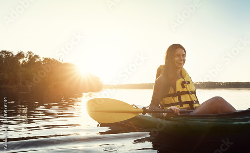 Im glad I got to go kayaking. a beautiful young woman kayaking on a lake outdoors. © Grady R/peopleimages.com