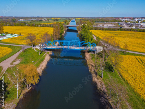 bridge crossing canal in rape fields