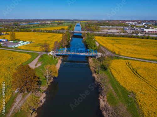 bridge crossing canal in rape fields