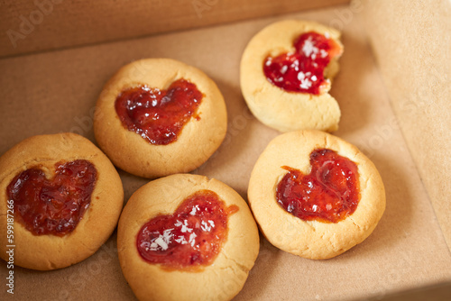 Cookies with strawberry jam in a paper box, close-up