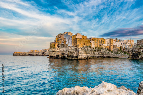 Scenic view of Polignano a Mare in Apulia in Italy against dramatic sunset sky photo