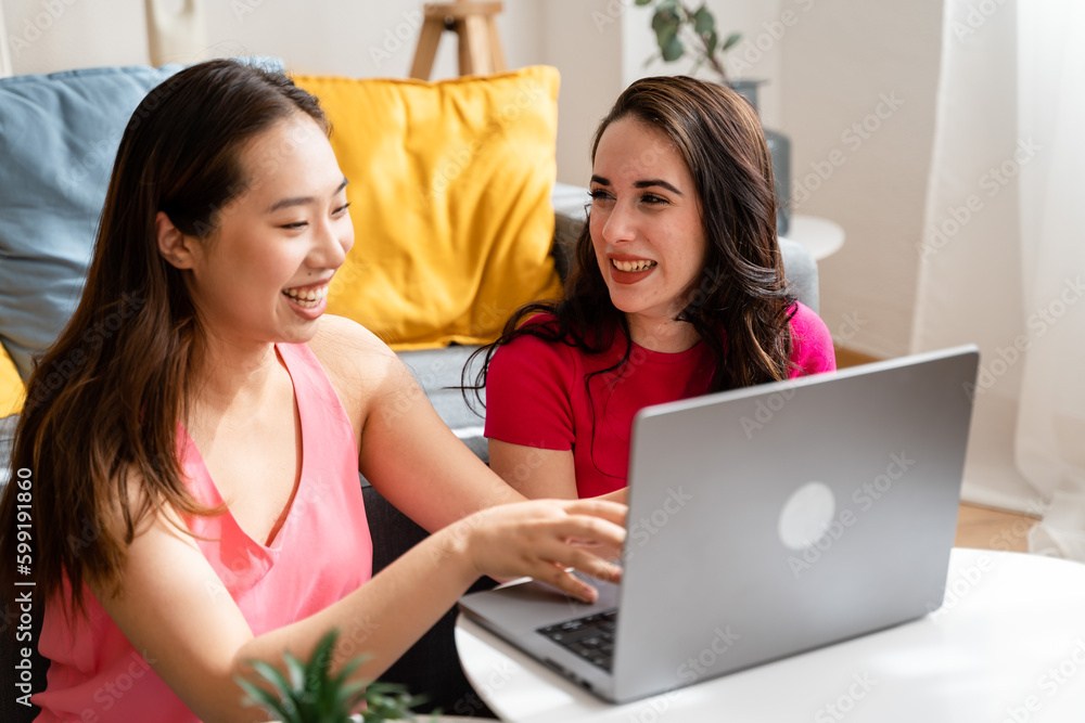 Two women using laptop in living room. Two women using laptop in living room.