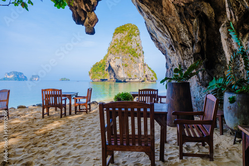 restaurant with chairs on the beach at a limestone cliff grotto at Railai Beach Krabi Thailand photo