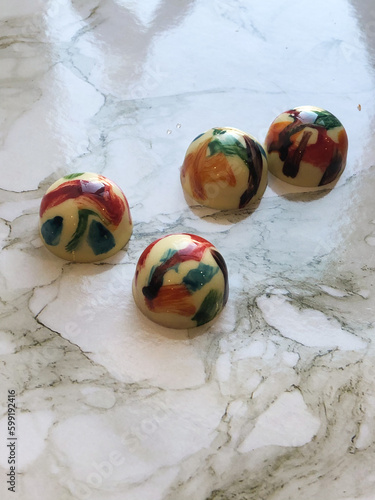 Round multicolored handmade candies on a marble surface