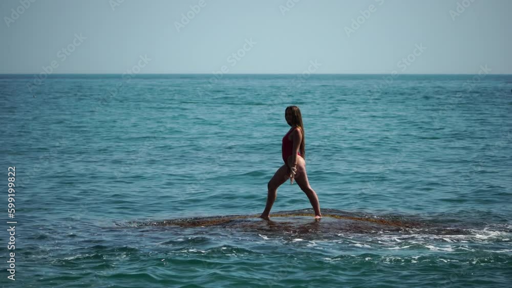 Woman sea yoga. Back view of free calm happy satisfied woman with long hair standing on top rock with yoga position against of sky by the sea. Healthy lifestyle outdoors in nature, fitness concept Woman sea yoga. Back view of free calm happy satisfied woman with long hair standing on top rock with yoga position against of sky by the sea. Healthy lifestyle outdoors in nature, fitness concept