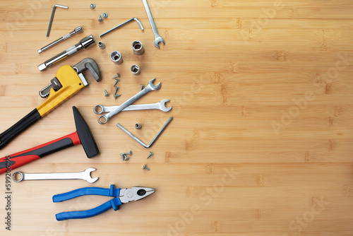 A set of working tools, a hammer, a screwdriver, adjustable spanner, sockets for repair on a bamboo, wooden background. Flat lay
