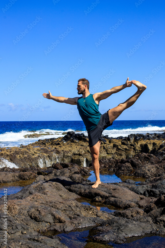 Atleta en la playa dando una patada al aire. Concepto de salud y deporte. Espacio para texto