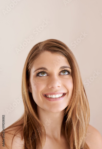 I like what I am seeing. Studio shot of a beautiful bare-shouldered model smiling and looking up at copyspace.