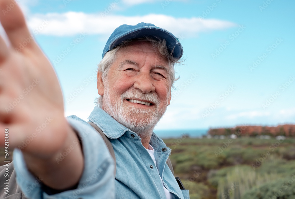 Portrait of happy senior bearded man outdoors in trekking day looking at camera. Elderly grandfather smiling enjoying healthy lifestyle and nature. Portrait of happy senior bearded man outdoors in trekking day looking at camera. Elderly grandfather smiling enjoying healthy lifestyle and nature.