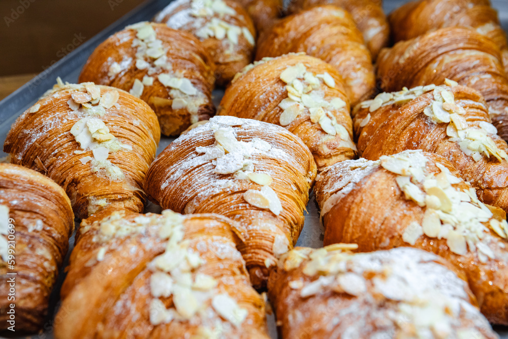 Sprinkle the finished croissants on a baking sheet with almond flakes