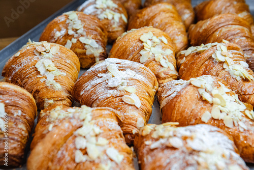 Obraz na płótnie Sprinkle the finished croissants on a baking sheet with almond flakes w salonie