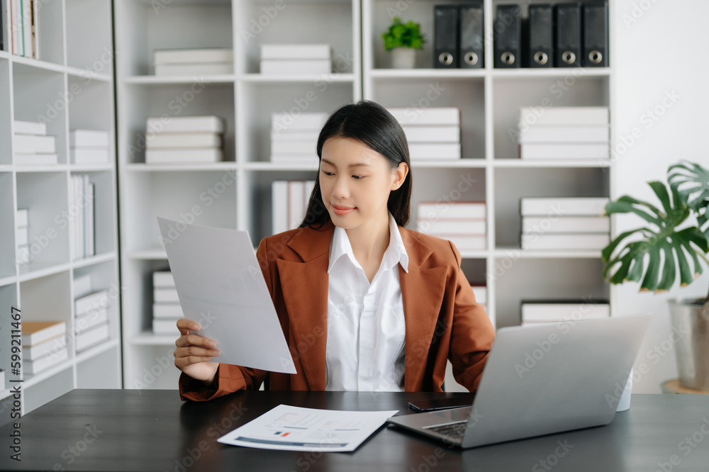 Business woman using tablet and laptop for doing math finance on an office desk, tax, report, accounting, statistics, and analytical research concept in office Business woman using tablet and laptop for doing math finance on an office desk, tax, report, accounting, statistics, and analytical research concept in office