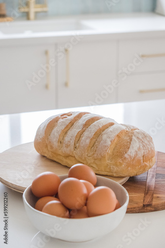 Fresh baked bread and eggs on a kitchen bench. photo