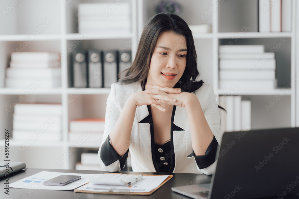 Cheerful business lady working on laptop in office, Asian happy beautiful businesswoman in formal suit work in workplace. Attractive female employee office worker smile. Cheerful business lady working on laptop in office, Asian happy beautiful businesswoman in formal suit work in workplace. Attractive female employee office worker smile.