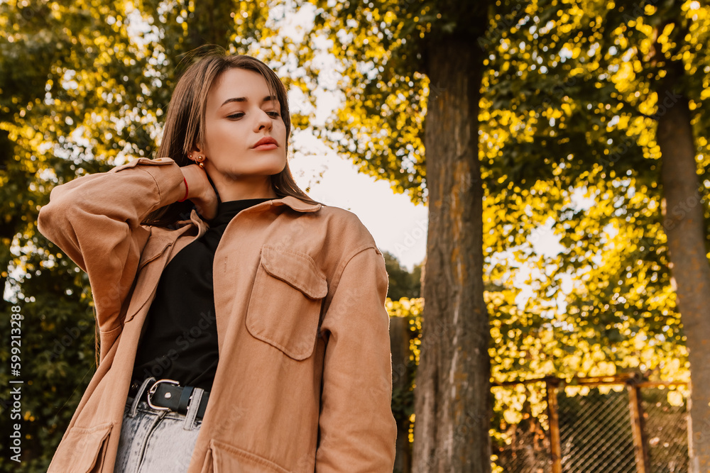 Caucasian young pretty stylish woman standing outside street dressed brown trench coat smiling poses outside city, spring autumn season nature sunshine light leaks. Cute brunette hair lady
Caucasian young pretty stylish woman standing outside street dressed brown trench coat smiling poses outside city, spring autumn season nature sunshine light leaks. Cute brunette hair lady
