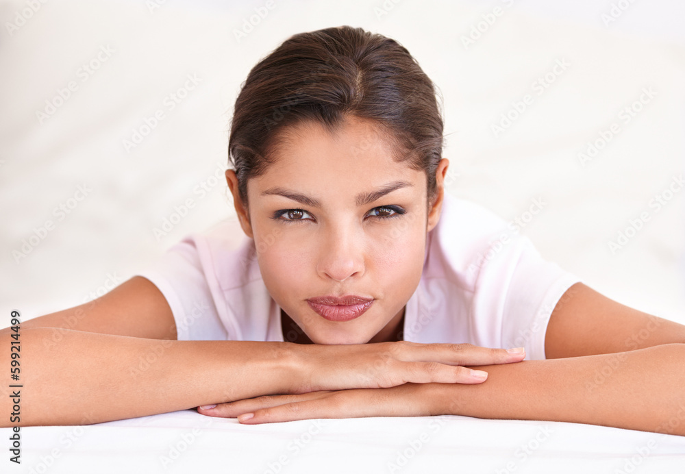 The picture of natural beauty. A young ethnic woman lying on her arms and looking at the camera. The picture of natural beauty. A young ethnic woman lying on her arms and looking at the camera.