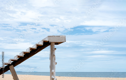 Stairs up to the sky by the sea at the beach in sunny day Summer,White Wooden staircase ladder with clear blue sky and clouds at seaside with copy space for text.Peaceful landscape Stairway to heaven