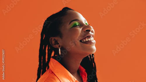 Bild auf Leinwand Happy african woman with makeup smiling with her eyes closed