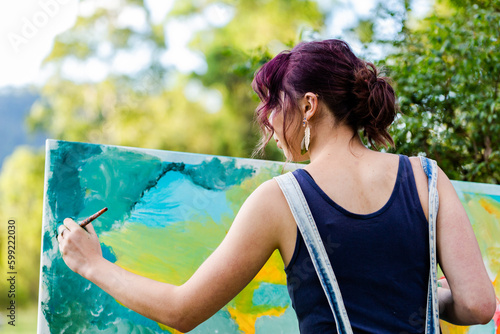 Young painter in overalls painting picture photo