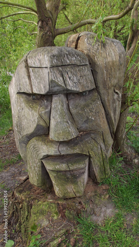 carved wood head of a man mounted on a stump