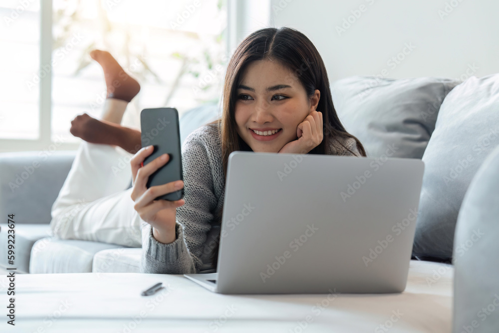 Happy woman enjoy lazy weekend resting on cozy sofa at home using smartphone chatting in social networks, lying on couch in living room Happy woman enjoy lazy weekend resting on cozy sofa at home using smartphone chatting in social networks, lying on couch in living room