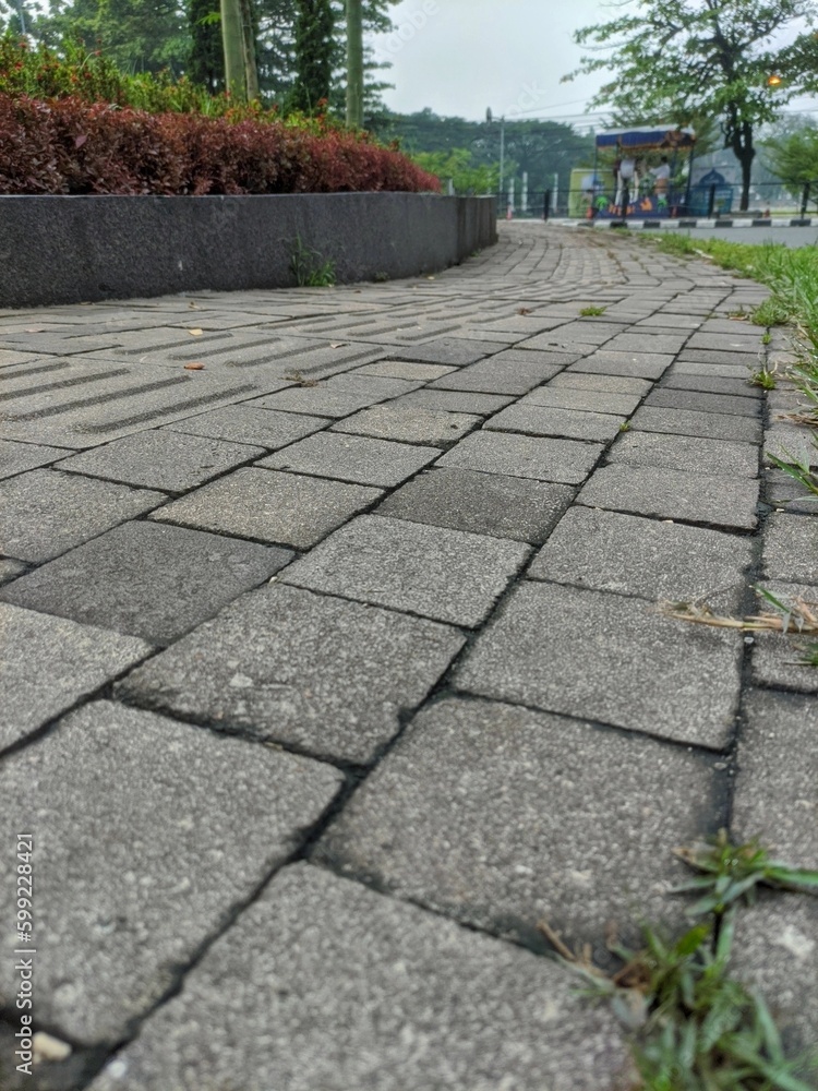 Fototapeta premium Background texture of a close-up cobblestone or paving slabs walkway in Bandung. Can be used for texture design and background with copy space.