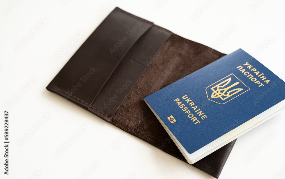 Ukrainian passport with a leather cover on a white background, selective focus. Inscription in Ukrainian Ukraine Passport. Ukrainian passport with a leather cover on a white background, selective focus. Inscription in Ukrainian Ukraine Passport.