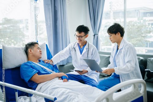 Hospital Ward Male and  Male Professional Asian Doctors Talk with a Patient  Give Health Care Advice  Recommend Treatment Plan  with Advanced Equipment
