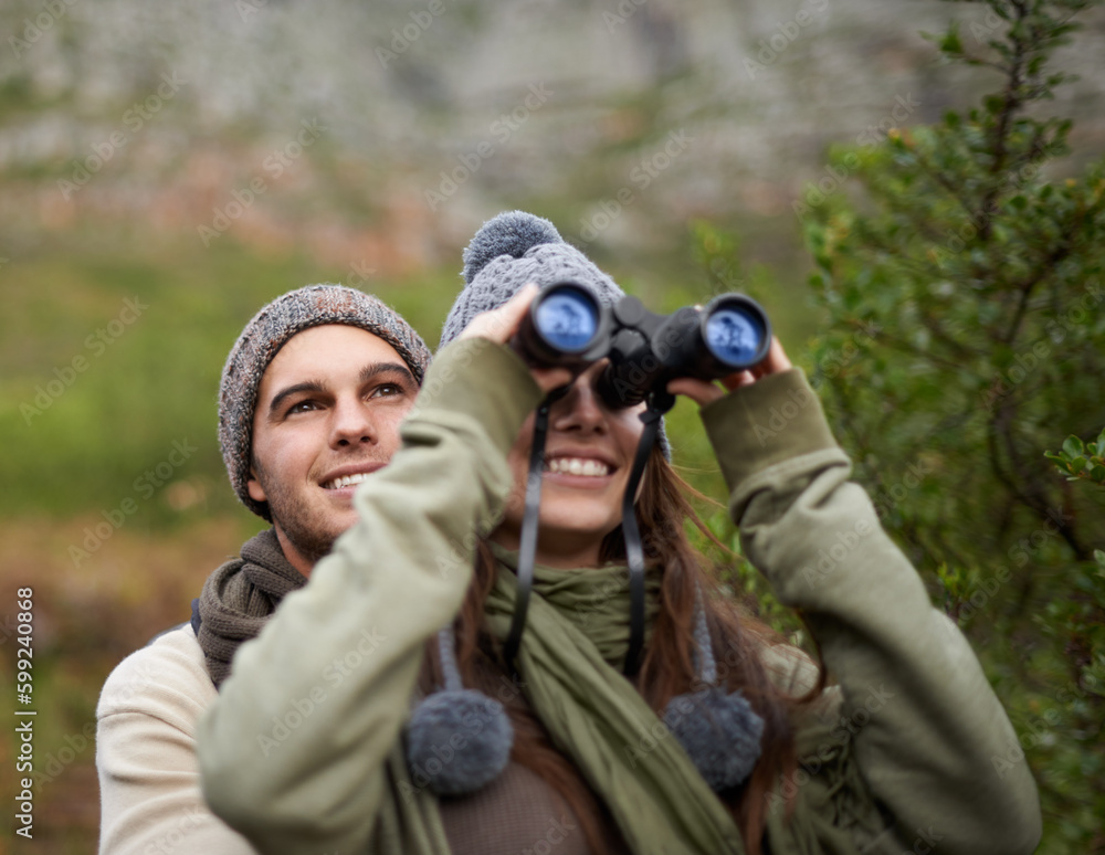 Taking in the sights while hiking to the top. A young couple taking in all the scenary while enjoying a mountain hike. Taking in the sights while hiking to the top. A young couple taking in all the scenary while enjoying a mountain hike.