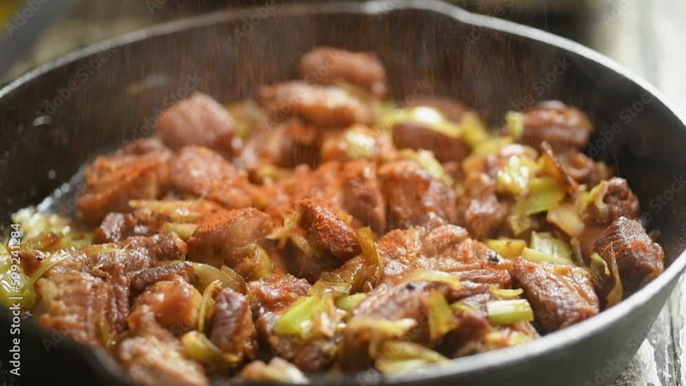The chef adds smoked paprika to the pork meat with leek in the frying pan.
The chef adds smoked paprika to the pork meat with leek in the frying pan.