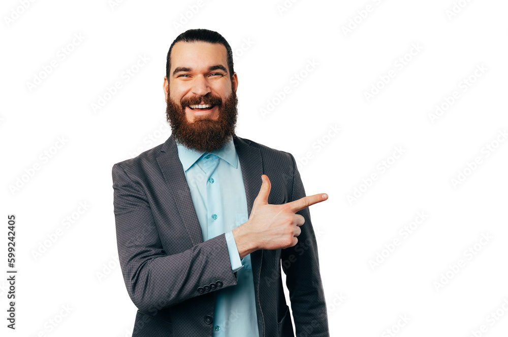 Handsome smiling bearded man wearing a jacket is pointing aside at white copy space. Handsome smiling bearded man wearing a jacket is pointing aside at white copy space.