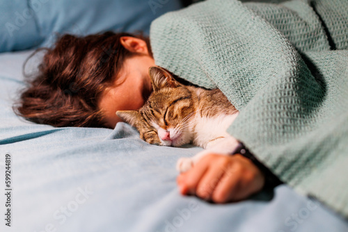 Tableau sur toile boy falls asleep and hugs his cat, who sleeps with him under the covers