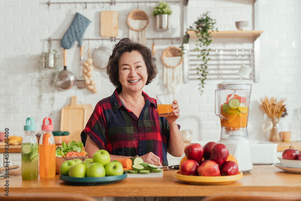 healthy asian aunt retired female woman enjoy making cook clean food breakfast for her healthy food lifestyle,smiling cheerful woman chopping fresh vegetable fruit making smoothie drink at home