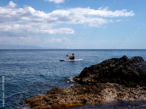 Surfista su una tavola da stand-up paddle nel Mar Mediterraneo.