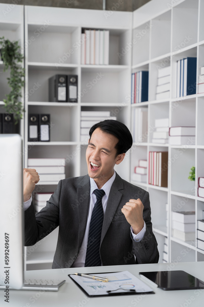 Successful business man, excited young man Keeping up arms and showing positive emotions, happy working in modern office on computer. Successful business man, excited young man Keeping up arms and showing positive emotions, happy working in modern office on computer.