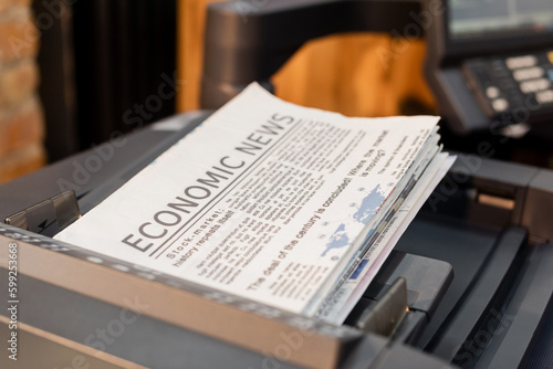 freshly printed newspapers with economic news inside of professional printer.