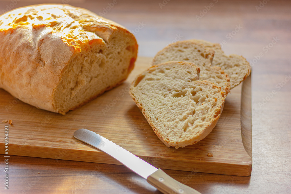 close up fresh white sliced bread and knife on wooden table in the kitchen close up fresh white sliced bread and knife on wooden table in the kitchen