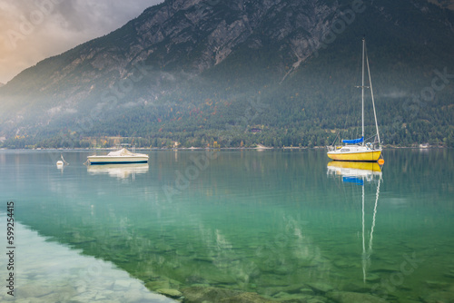 Sailboats in Achensee lake near Innsbruck at peaceful dawn, Tyrol alps, Austria