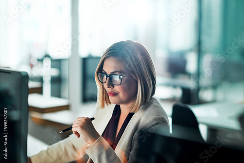 Taking small ideas online to make it bigger. a businesswoman sitting at her desk. photo