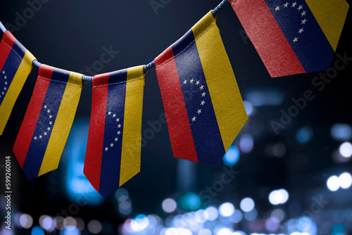 Fototapeta Naklejka Na Ścianę i Meble -  A garland of Venezuela national flags on an abstract blurred background