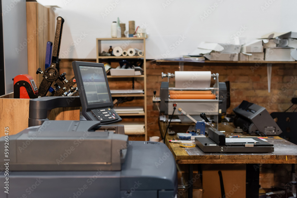 modern print center equipment next to monitor and paper trimmer. modern print center equipment next to monitor and paper trimmer.