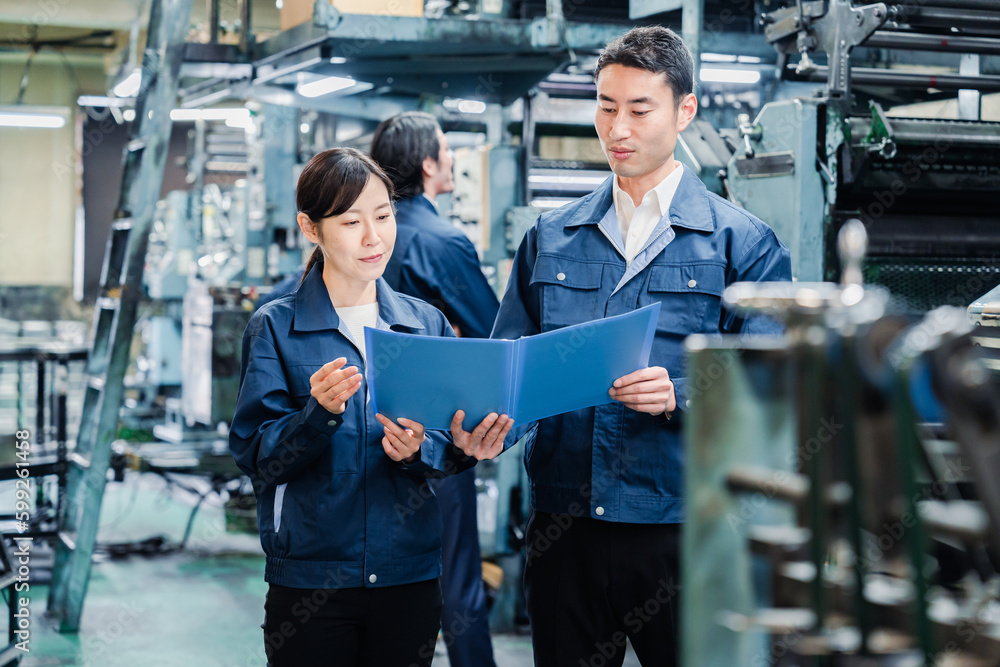 工場で生産計画を確認する労働者 工場で生産計画を確認する労働者