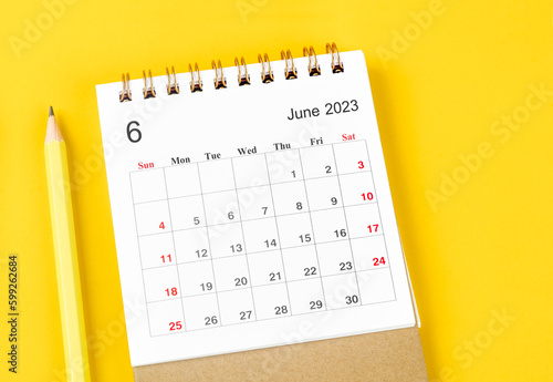 The June 2023 Monthly desk calendar for 2023 with pencil on yellow background.