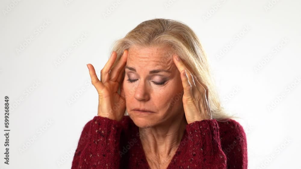 Closeup of tired depressed elderly mature woman 50s with migraine headache posing isolated on white background studio. Portrait of people lifestyle concept. Put hands face temples Closeup of tired depressed elderly mature woman 50s with migraine headache posing isolated on white background studio. Portrait of people lifestyle concept. Put hands face temples